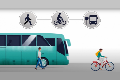 záber z video spotu s autobusom, bicyklom a chodcom