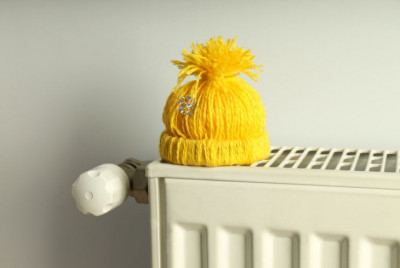 Žltá zimná čapica položená na radiátore