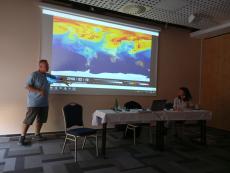 The lecturer presents the circulation of dust from agriculture in the atmosphere