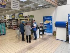 people in supermarket in front of the Populair info point